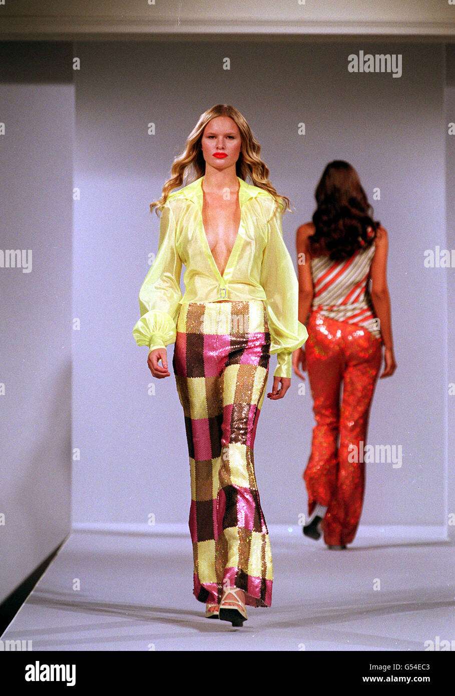 Un modello indossa una blusa gialla non bottonata e pantaloni a scacchi della designer Maria Grachvogel ad Harrods, durante la London Fashion Week. Foto Stock
