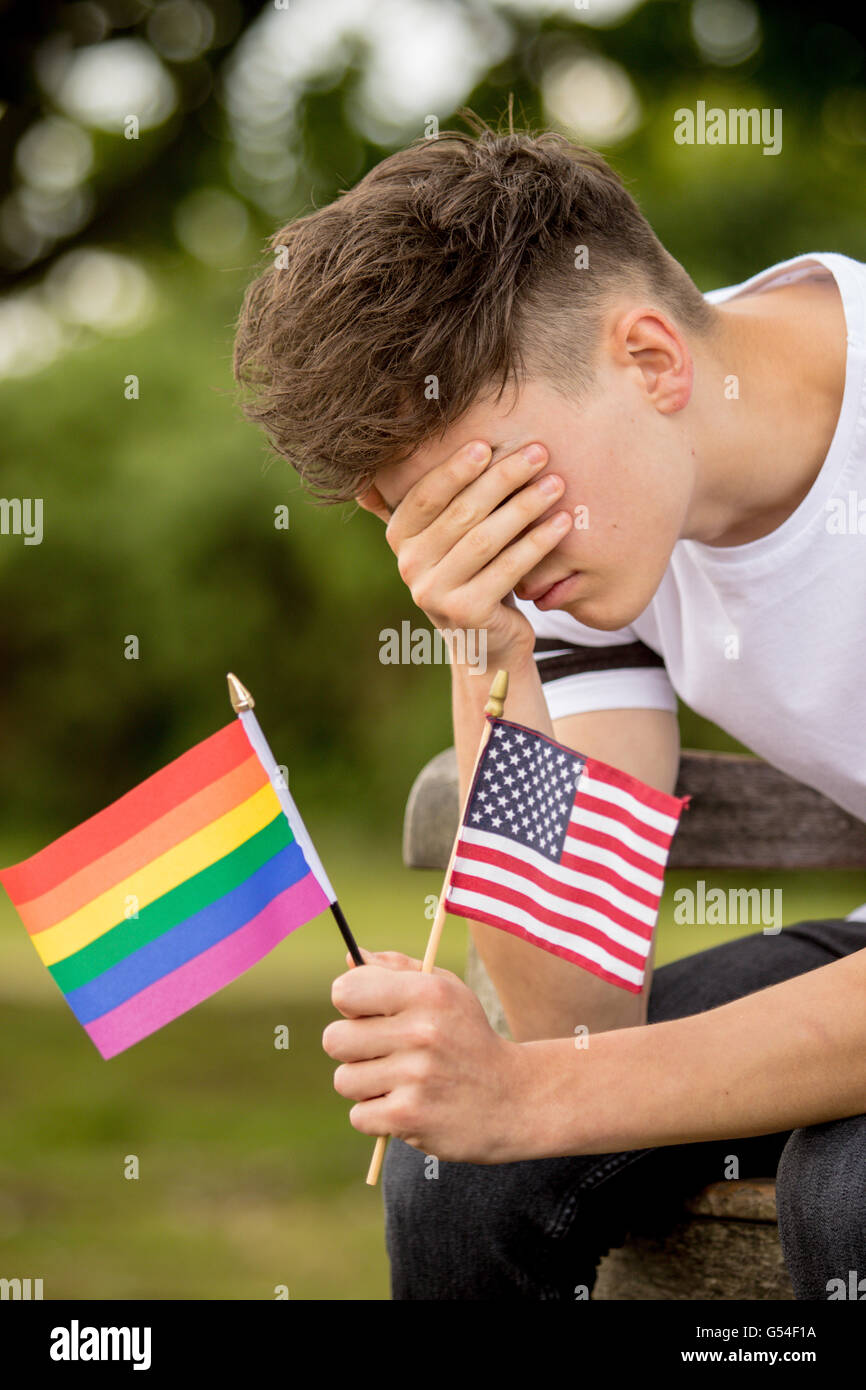 Premuto ragazzo adolescente con Stati Uniti bandiera e un orgoglio bandiera Foto Stock