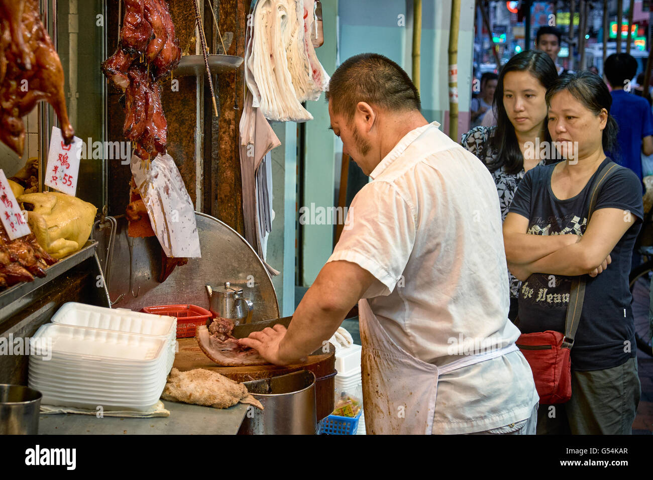 I clienti in coda e l'acquisto delle selezioni di portar via il cibo cotto in un negozio di Shanghai Street in Yau Ma Tei, Hong Kong. Foto Stock