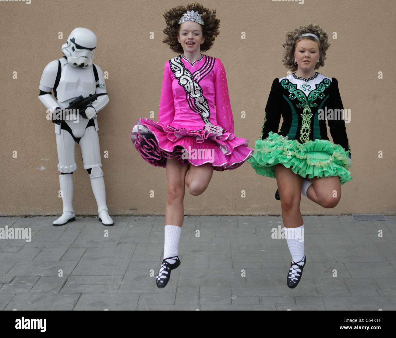 Sarah Duggan, 13, (a sinistra) e Shannon Tone, 14, praticano la danza irlandese accanto ad un uomo vestito come un Trooper Storm dalle guerre delle Stelle del film, mentre si riuniscono oggi alla Convention Citywest di Dublino, Per l'Invasion Dublin Star Wars Convention e i campionati aperti di danza irlandese si svolgono entrambi questo fine settimana. Foto Stock