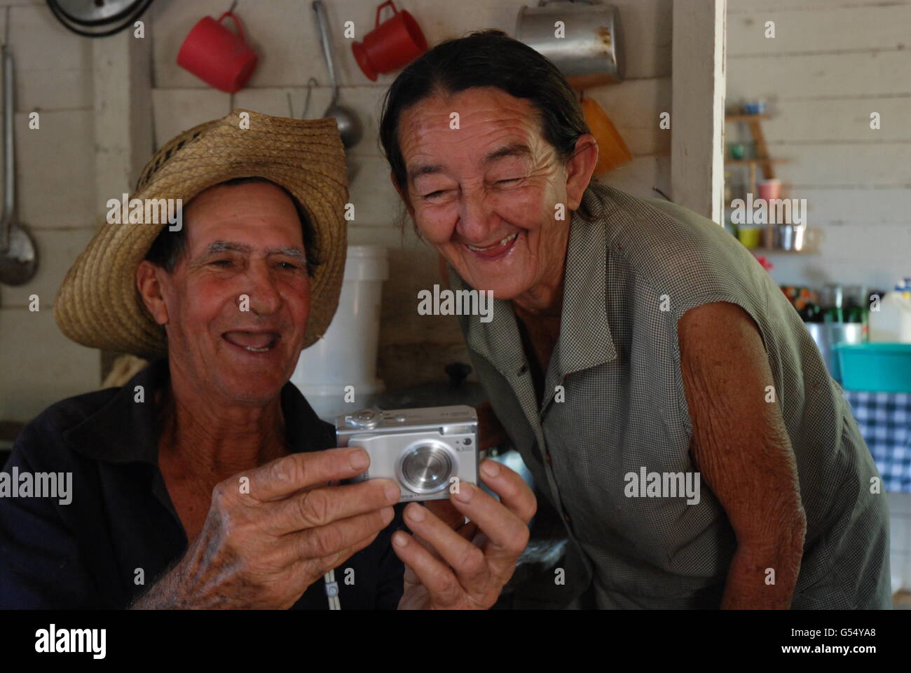 Un tabacco cubano agricoltore in Vinales e sua moglie ridere come si visualizza una foto di loro stessi su una fotocamera Canon Foto Stock