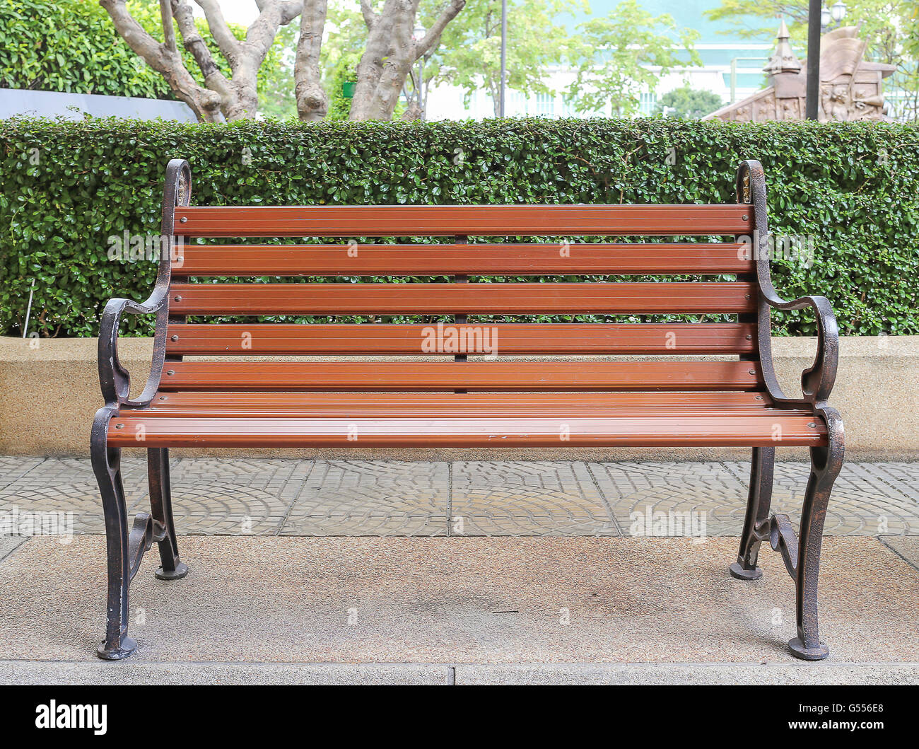 Banco di marrone in stile vintage giardino interno che avente boccola e albero come sfondo Foto Stock