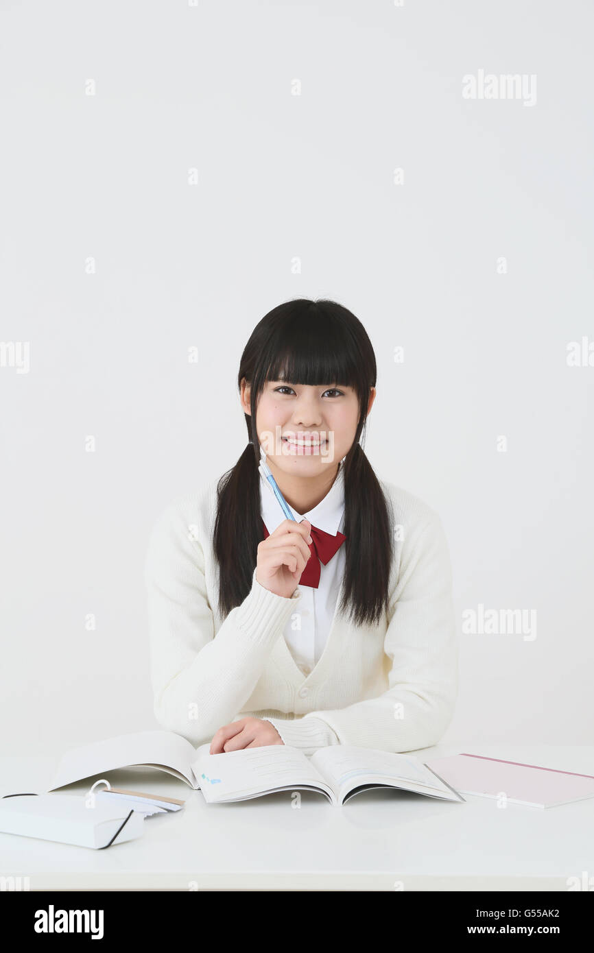 Giapponese di alta scuola di studente in uniforme contro uno sfondo bianco Foto Stock