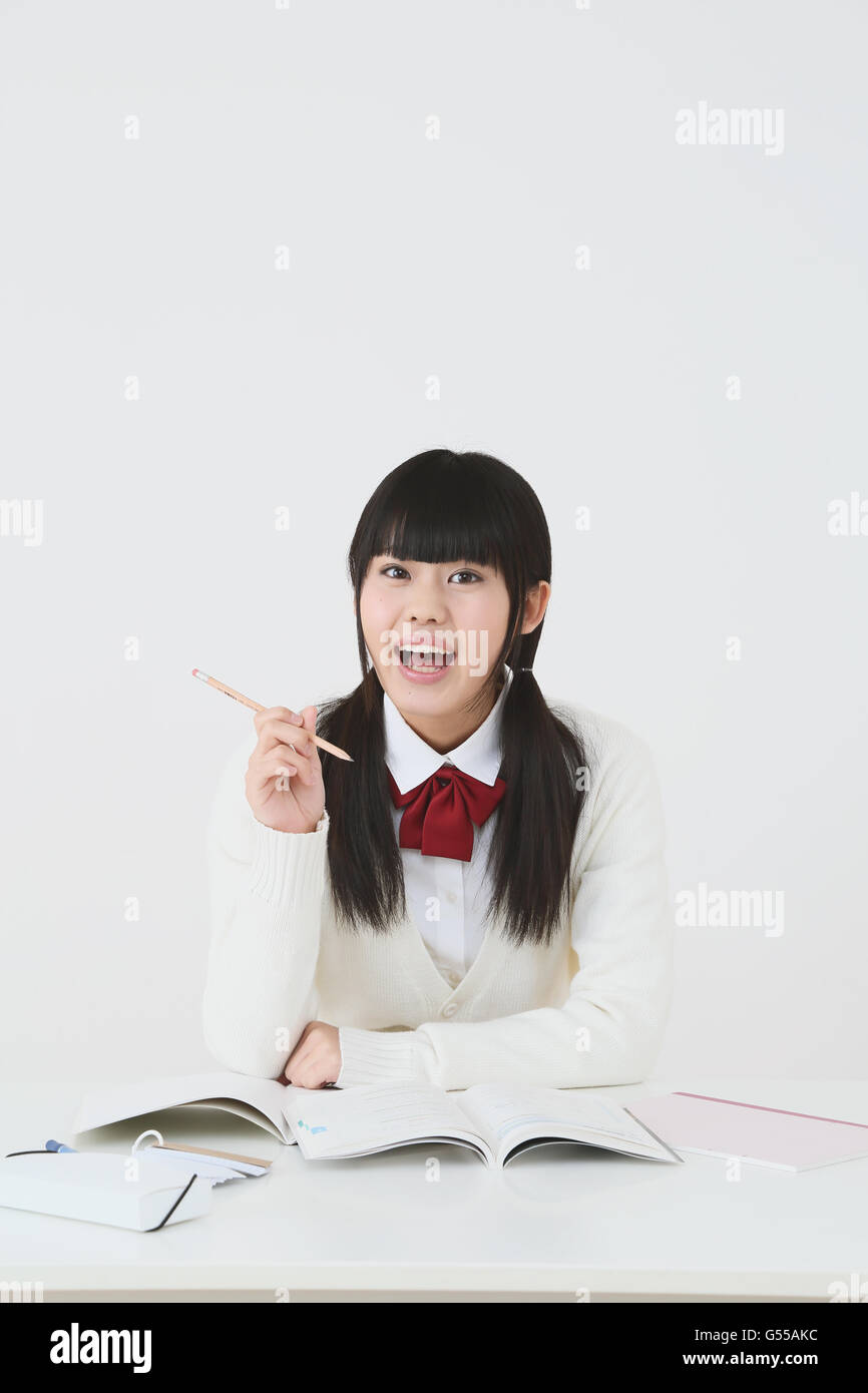 Giapponese di alta scuola di studente in uniforme contro uno sfondo bianco Foto Stock