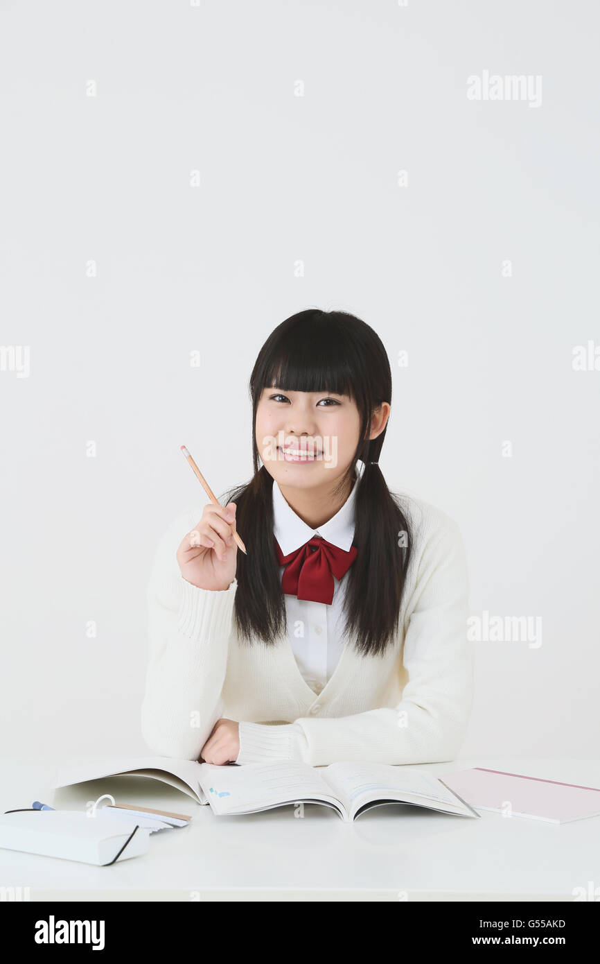 Giapponese di alta scuola di studente in uniforme contro uno sfondo bianco Foto Stock