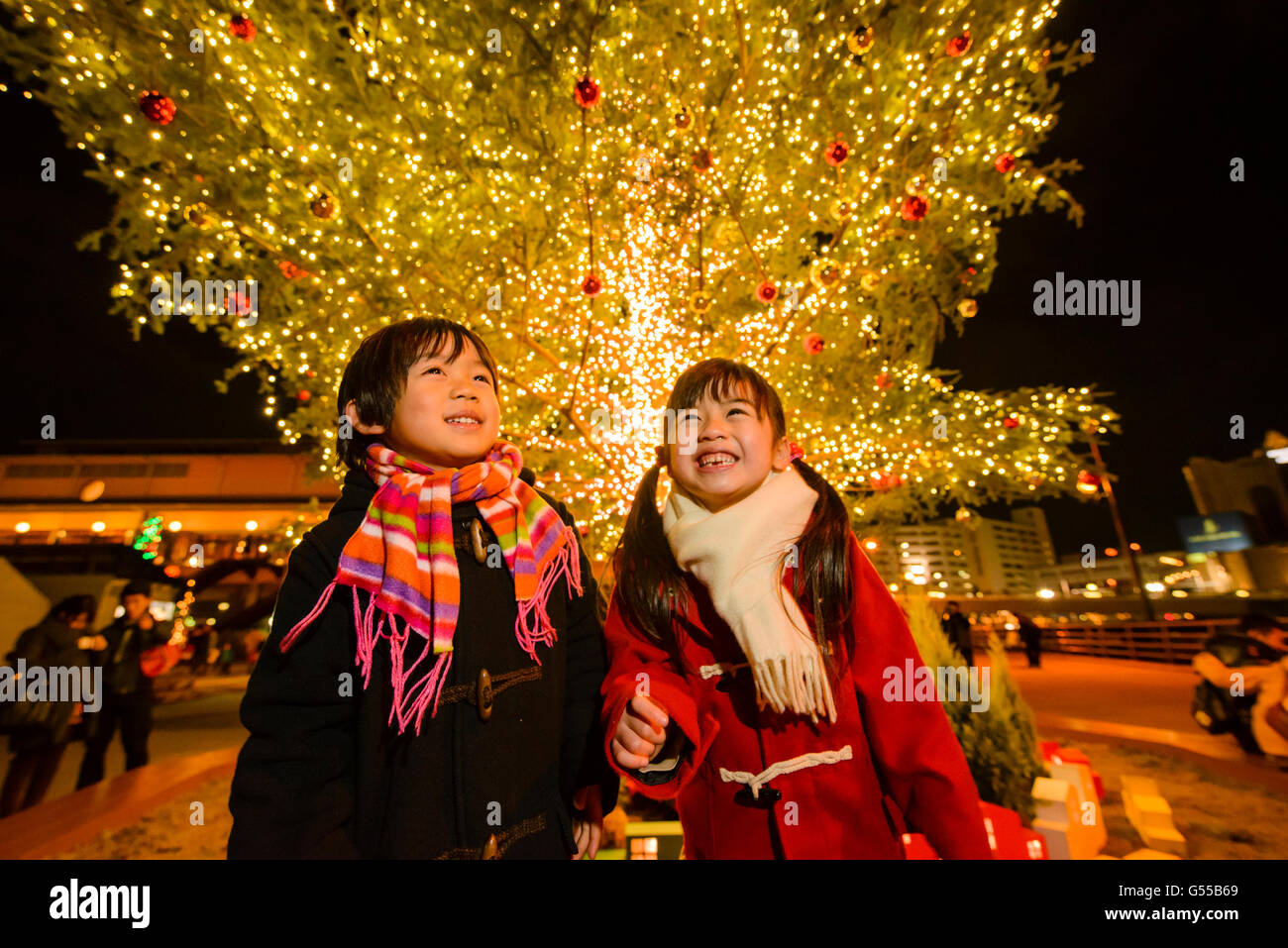 Il giapponese per i ragazzi al di sotto dei outdoor albero di Natale Foto Stock