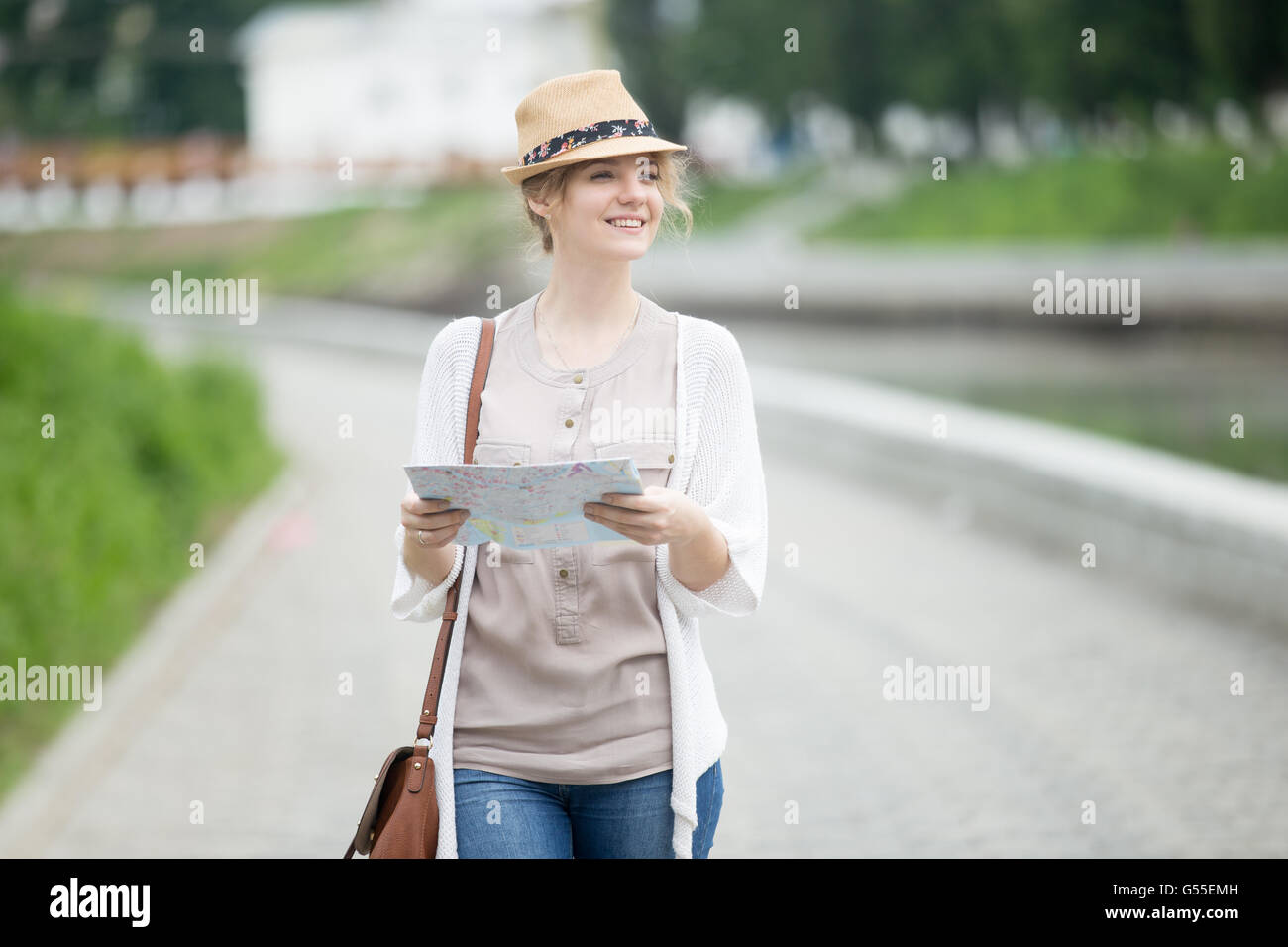 Ritratto di donna informale viaggiatore ricerca Direzione sulla mappa di localizzazione. Giovani donne in viaggio a piedi con mappa durante visite turistiche Foto Stock