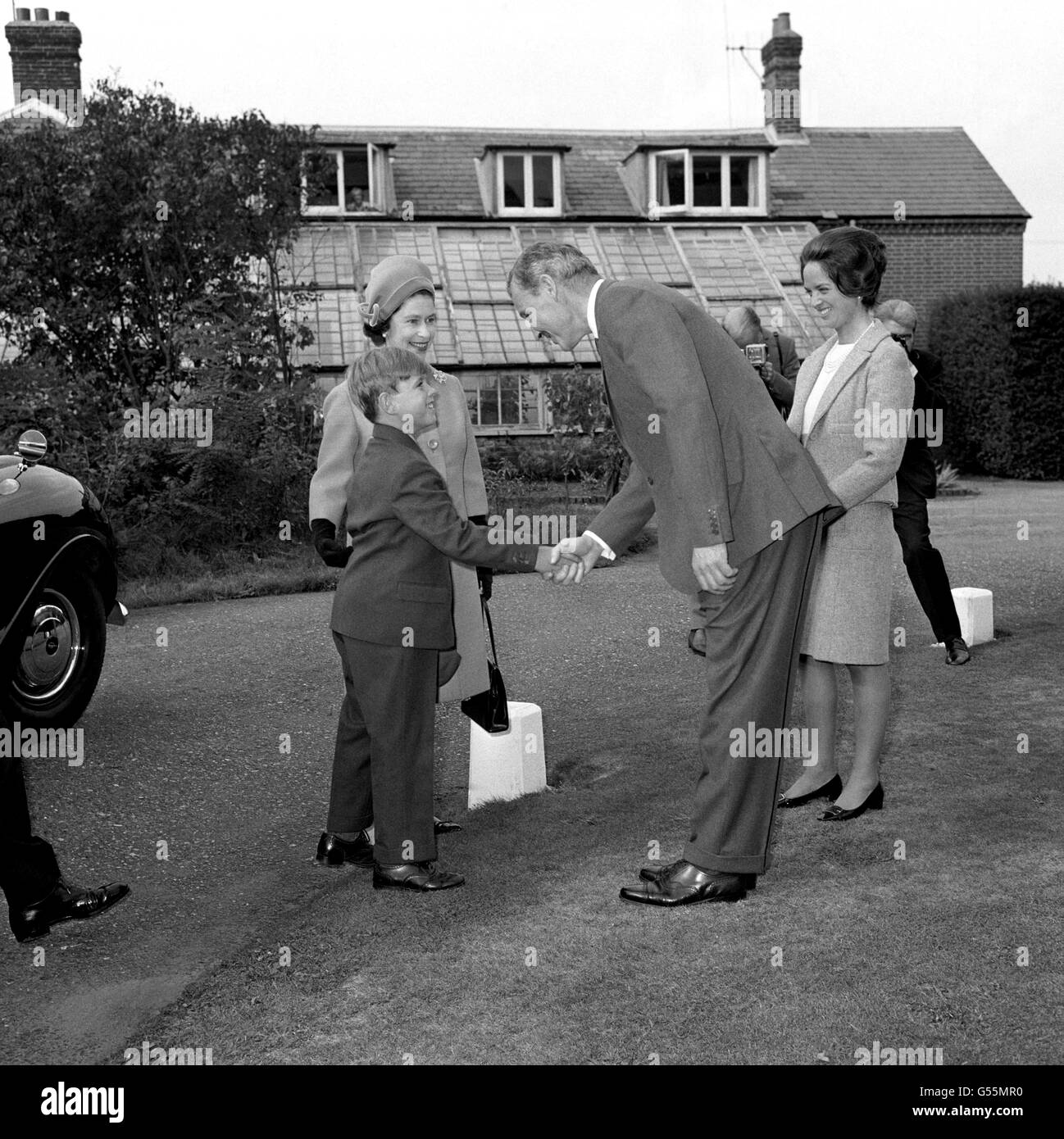 Il principe Andrew, il futuro duca di York, di otto anni, e sua madre la regina Elisabetta II (a sinistra, sfondo), sono accolti all'arrivo alla Heatherdown Preparatory School di Ascot, nel Berkshire, dal preside James Edwards e da Elizabeth Keeling, sorella gemella della moglie del preside. Foto Stock