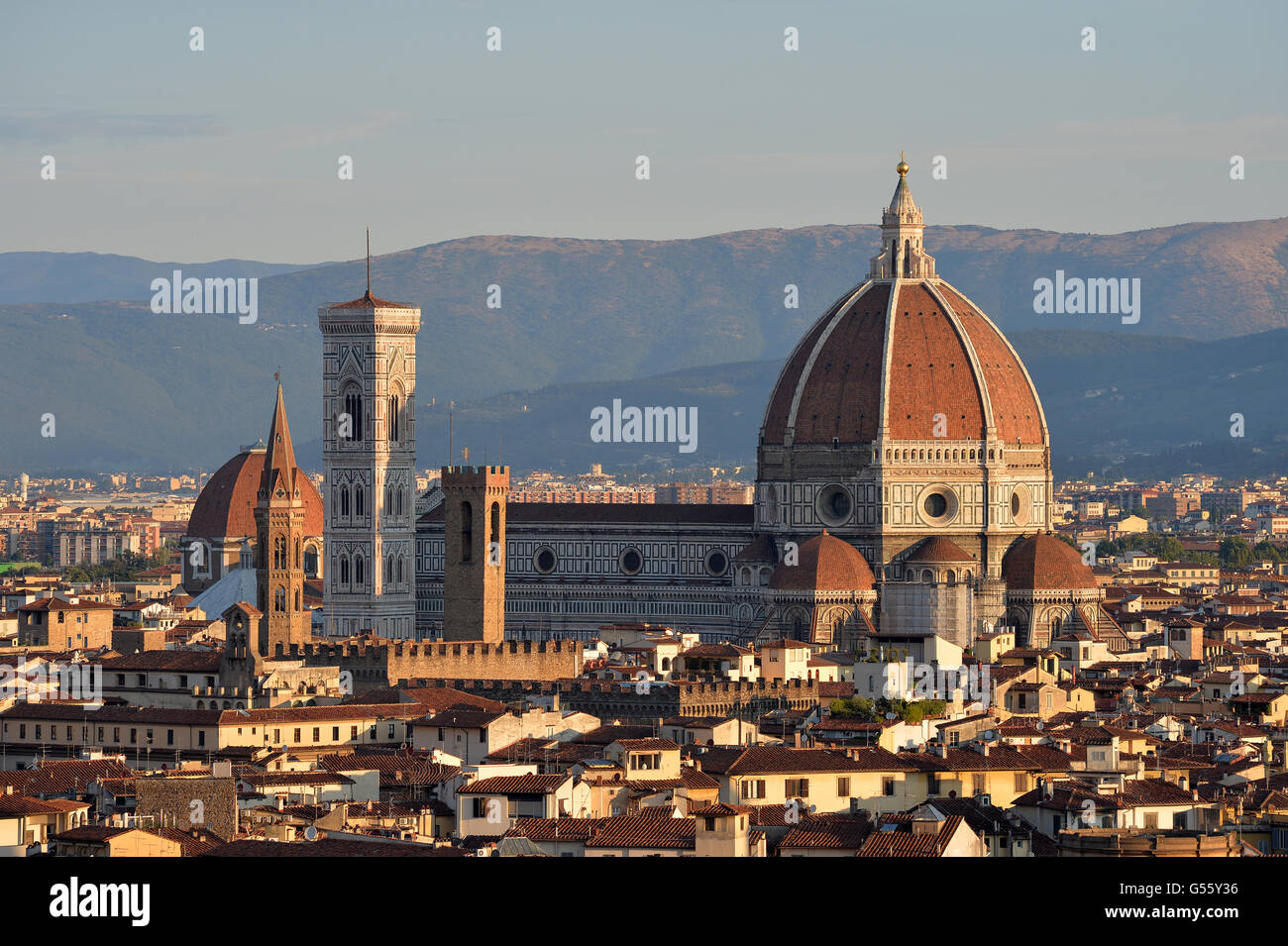 Cattedrale la Basilica di Santa Maria del Fiore baciata dal caldo sole del mattino con le montagne sullo sfondo Firenze Italia Foto Stock