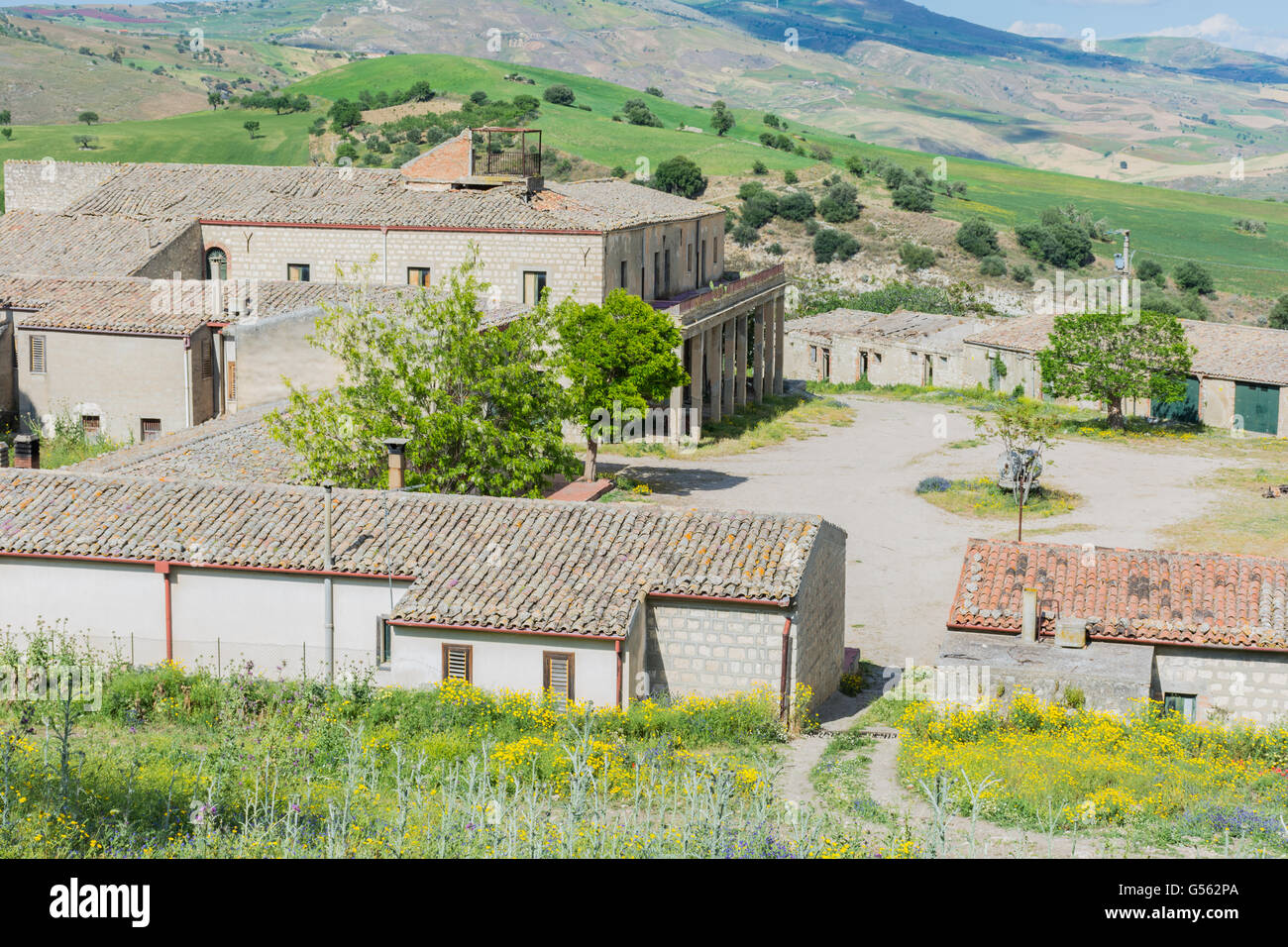 Panorama siciliano, con antica e moderna casa, con ulivi e mandorli in fiore. Foto Stock