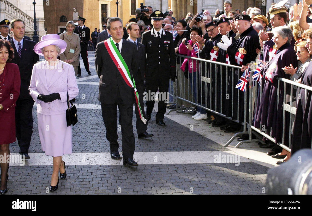 Regina Elisabetta II, a sinistra, scortata dal Sindaco di Roma Francesco Rutelli (centro con sash) è salutata dai monarchici italiani mentre cammina attraverso la piazza del municipio di Roma, Piazza Campidoglio, l'ultimo giorno della visita di Stato in Italia. Foto Stock