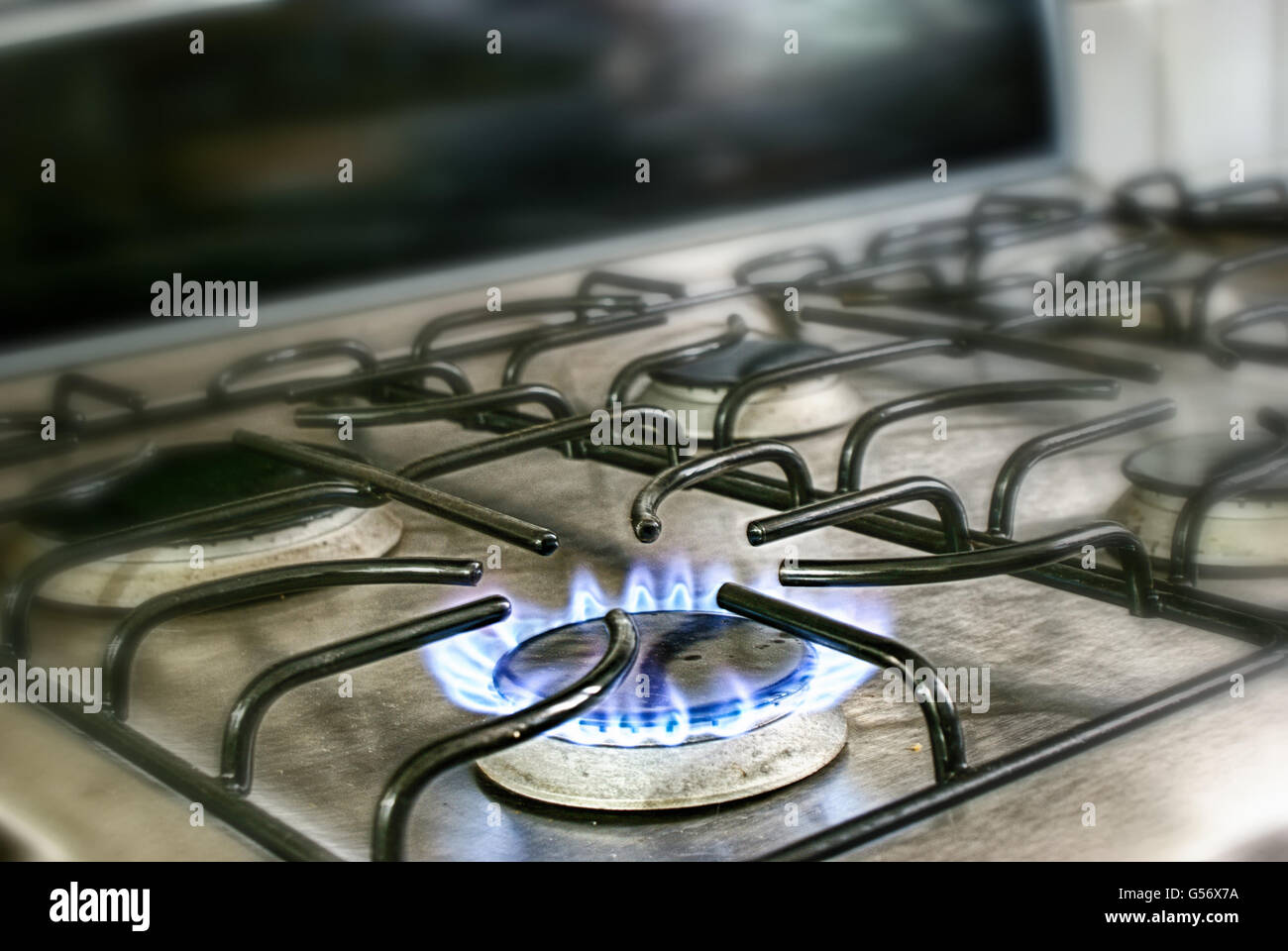 Fotografia di un metallo illuminato stufa a gas blu e vigili del fuoco di fiamma Foto Stock