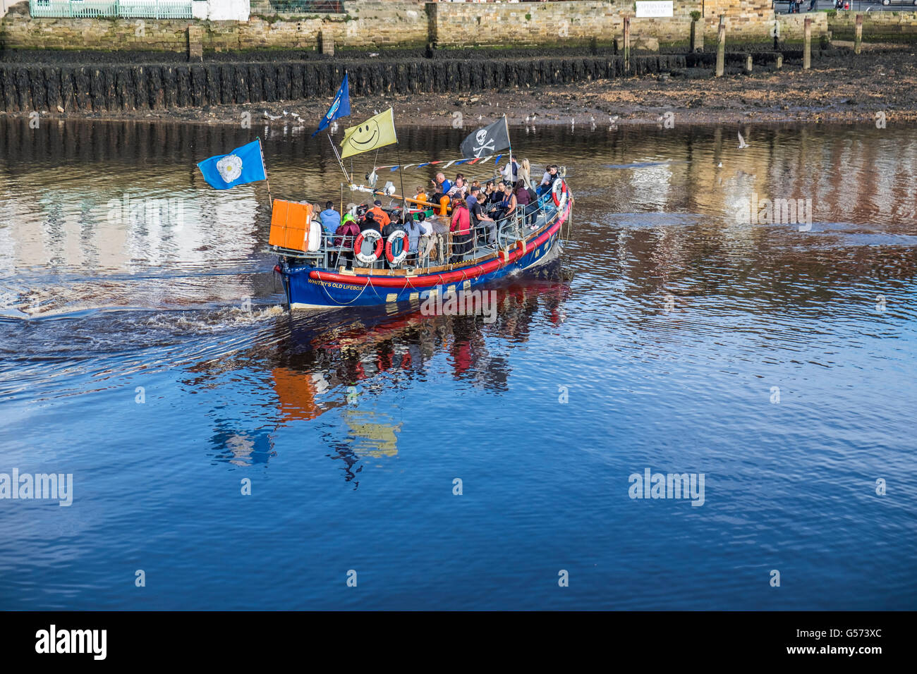 Vecchio Whitby scialuppa di salvataggio tenendo tourist vela round porto di Whitby nel periodo estivo con un sacco di persone a bordo. Foto Stock
