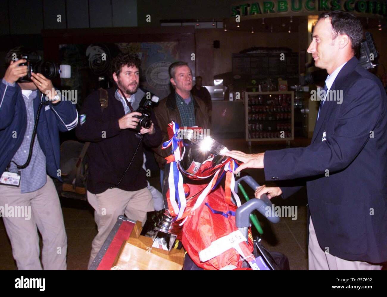 I fotografi si riuniscono in Inghilterra il capitano di cricket Nasser Hussain (a destra) ritorna all'aeroporto di Heathrow dal Pakistan dopo che l'Inghilterra ha battuto il Pakistan nella serie di test di Karachi. *...la vittoria nella prova finale ha portato l'Inghilterra la loro prima vittoria della serie sul suolo straniero dalla Nuova Zelanda 1996/97 e ha seguito i successi domestici sopra lo Zimbabwe e le Indie occidentali all'inizio di quest'anno. Hussain ha detto: "Finalmente abbiamo qualche ricompensa da riportare nel paese". Foto Stock