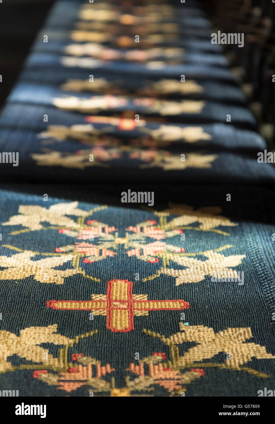 Christian simbolo religioso della croce su un kneeler presso una chiesa Derbyshire, Regno Unito. Foto Stock