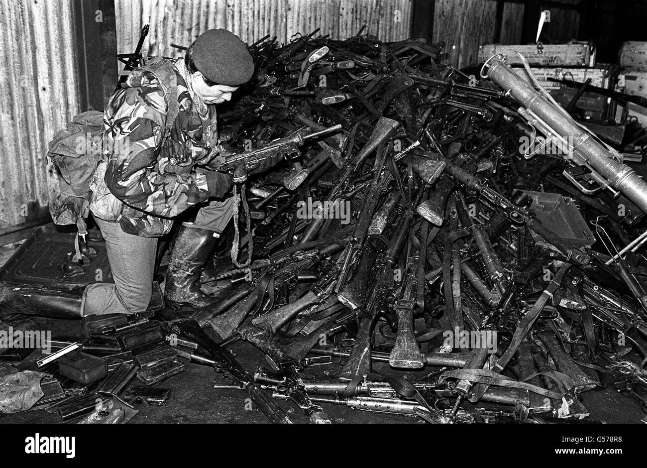 LA GUERRA DELLE FALKLANDS 1982: Un ufficiale dei Royal Marines esamina una mitragliatrice antiquata da un mucchio di armi automatiche deposte dalle truppe argentine alla resa verde dell'oca. Il verde d'oca fu catturato dagli uomini del reggimento di Parachute. *25/03/02 un ufficiale dei Royal Marines che esamina una mitragliatrice antiquata da un mucchio di armi automatiche deposte dalle truppe argentine alla resa verde dell'Oca nella guerra delle Falkland.il 20° anniversario dell'invasione delle Falklands da parte delle forze argentine sarà il 2 aprile 2002. Foto Stock