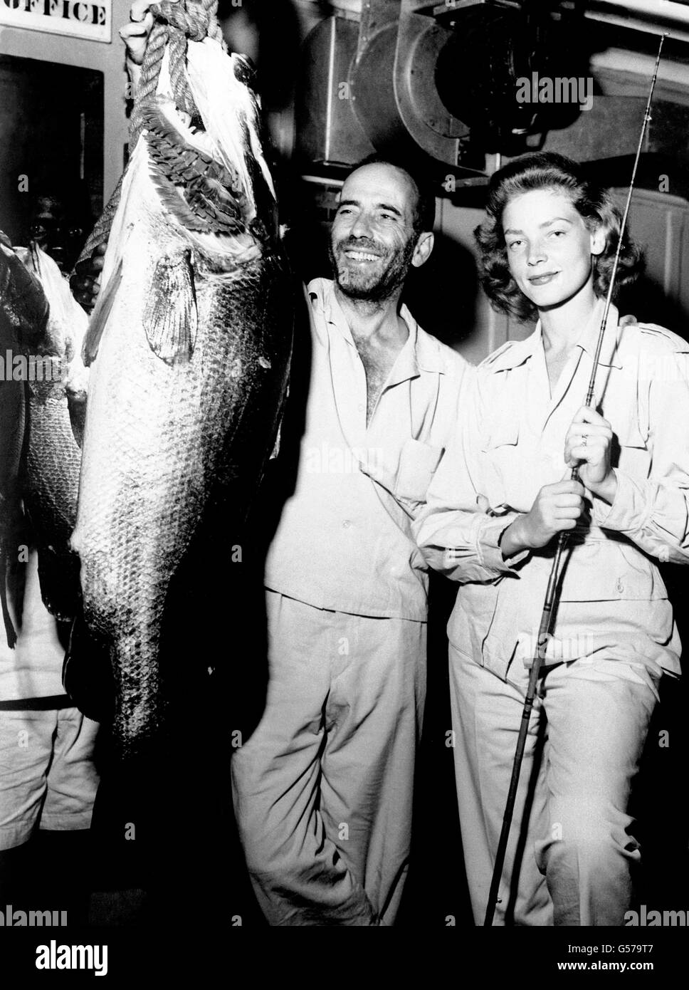 L'attore americano Humphrey Bogart e la sua attrice moglie Lauren Bacall con un Nile Perch, che ha catturato mentre in posizione in Africa per le scene esterne nel suo nuovo film 'la regina africana'. Foto Stock