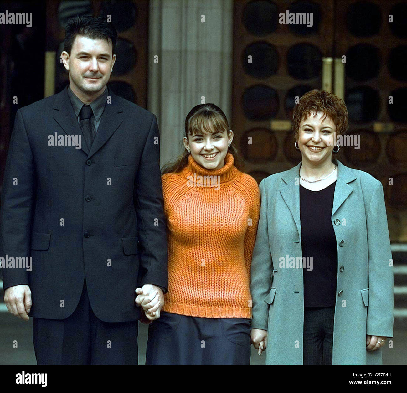 Il soprano infantile Charlotte Church (C) con sua madre, Maria, e lo steppfateher James, fuori dalla High Court di Londra, dove l'età di 14 anni e il suo ex manager Jonathan Shalit hanno risolto la loro disputa da milioni di sterline. * fine della battaglia amara del tribunale che began21/11/00. Dopo una mattinata di dispute legali tra le parti, Charlotte tornò in tribunale per gettare le braccia intorno al suo barrister, Richard Englehart, QC, e lo baciò in gratitudine. Foto Stock