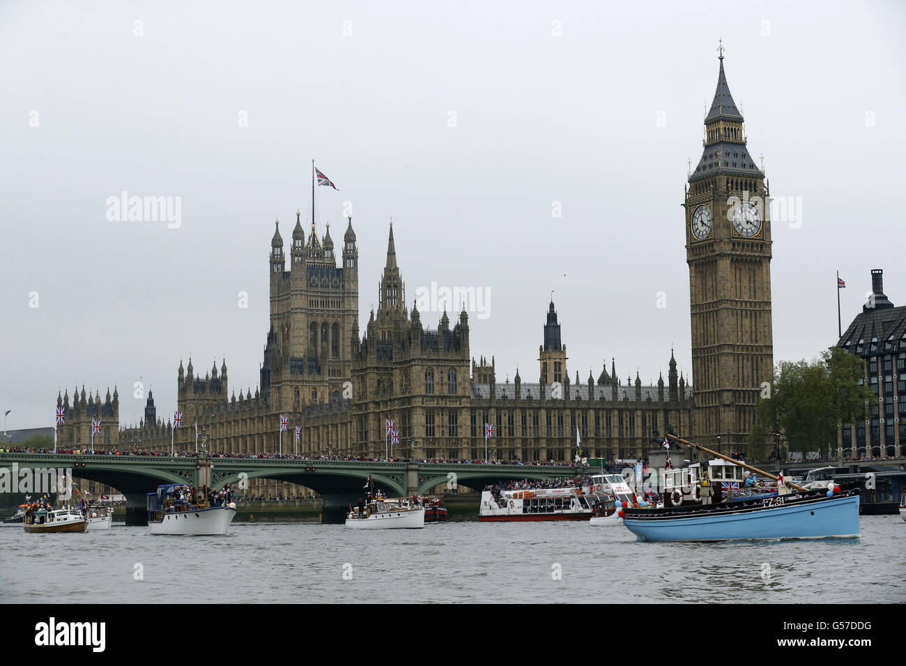 Le barche passano davanti alle Houses of Parliament mentre si dirigono verso il Tower Bridge lungo il Tamigi, durante il Diamond Jubilee River Pageant, a Londra. Foto Stock