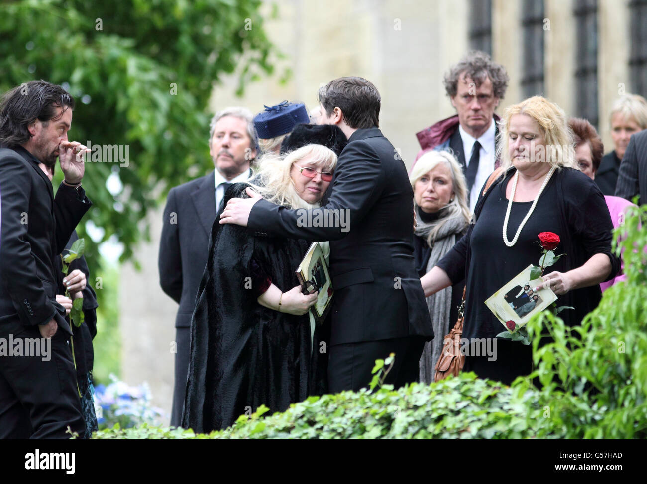 Dwina Murphy Gibb (a sinistra) abbraccia suo figlio RJ al funerale di suo marito, e suo padre, Bee Gee Robin Gibb alla chiesa di St Mary a Thame, Oxfordshire. Foto Stock