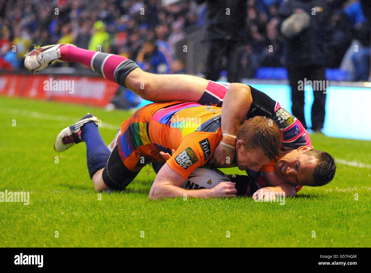 Rugby League - Stobart Super League - Warrington Wolves / Leeds Rhinos - Halliwell Jones Stadium. Chris Riley di Warrington Wolves segna il suo primo tentativo nonostante i migliori sforzi del Kevin Sinfield di Leeds Rhinos Foto Stock