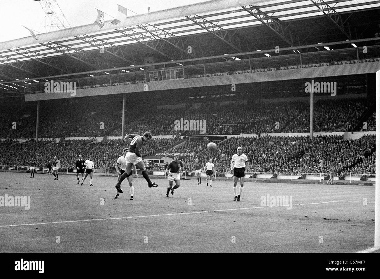COPPA DEL MONDO 1966: Geoff Hurst punta brillantemente all'obiettivo di mettere il livello inglese a 1-1 dopo lo shock della Germania occidentale in testa alla finale della Coppa del mondo a Wembley. Al centro si trova Roger Hunt e sulla destra Willi Schulz, la spazzatrice tedesca. Foto Stock
