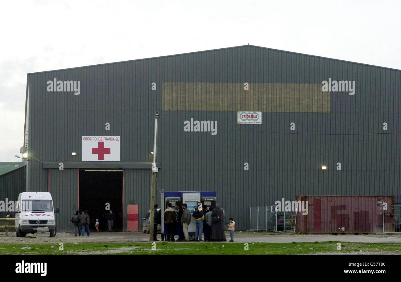 Rifugiati intorno al centro della Croce Rossa a Sangatte, nei pressi di Calais, il primo giorno di nuove procedure di sicurezza introdotte dall'operatore di traghetti P&o Stenna Line per ridurre il numero di immigrati clandestini che entrano in Gran Bretagna. 40 guardie di sicurezza hanno anche iniziato a cercare veicoli. * fare la fila per salire a bordo della barca a vela delle 7:00. *21/08/2001...il centro profughi della Croce Rossa a Sangatte, vicino a Calais, che l'operatore del tunnel della Manica Eurotunnel ha chiesto la chiusura di un tribunale francese. Eurotunnel ha detto che il campo conteneva un gran numero di richiedenti asilo la cui unica intenzione è quella di raggiungere il Regno Unito e che si sono rivali al terminal in Foto Stock