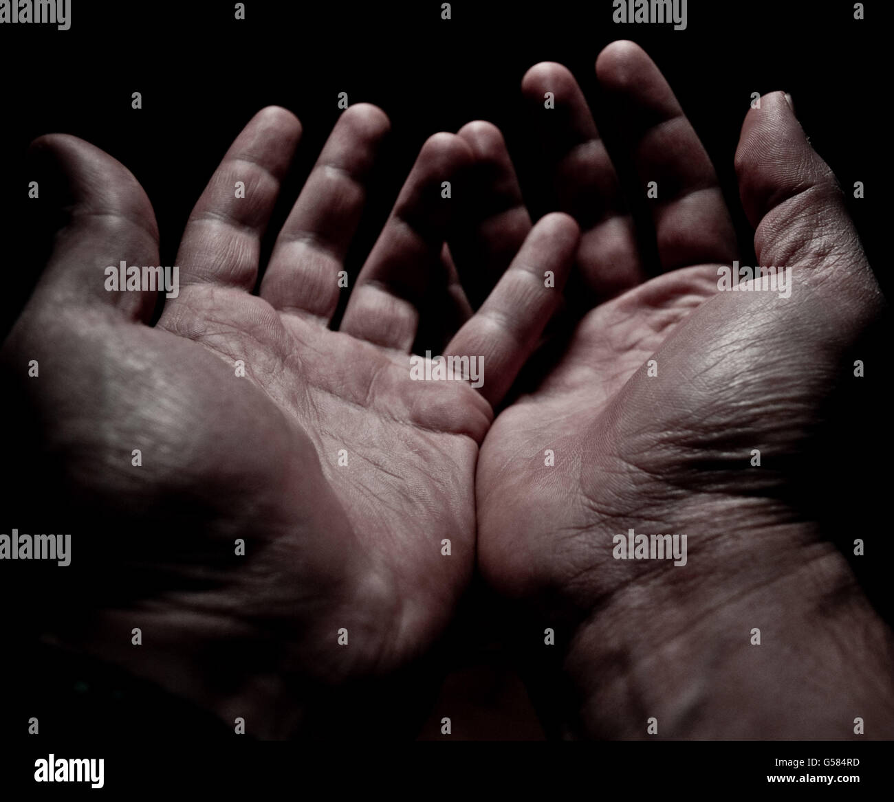 Gli uomini con le mani in mano per chiedere aiuto Foto Stock