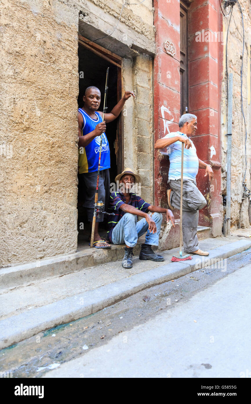 Havana street scene, tre uomini cubani in chat con La Habana Vieja, Cuba Foto Stock