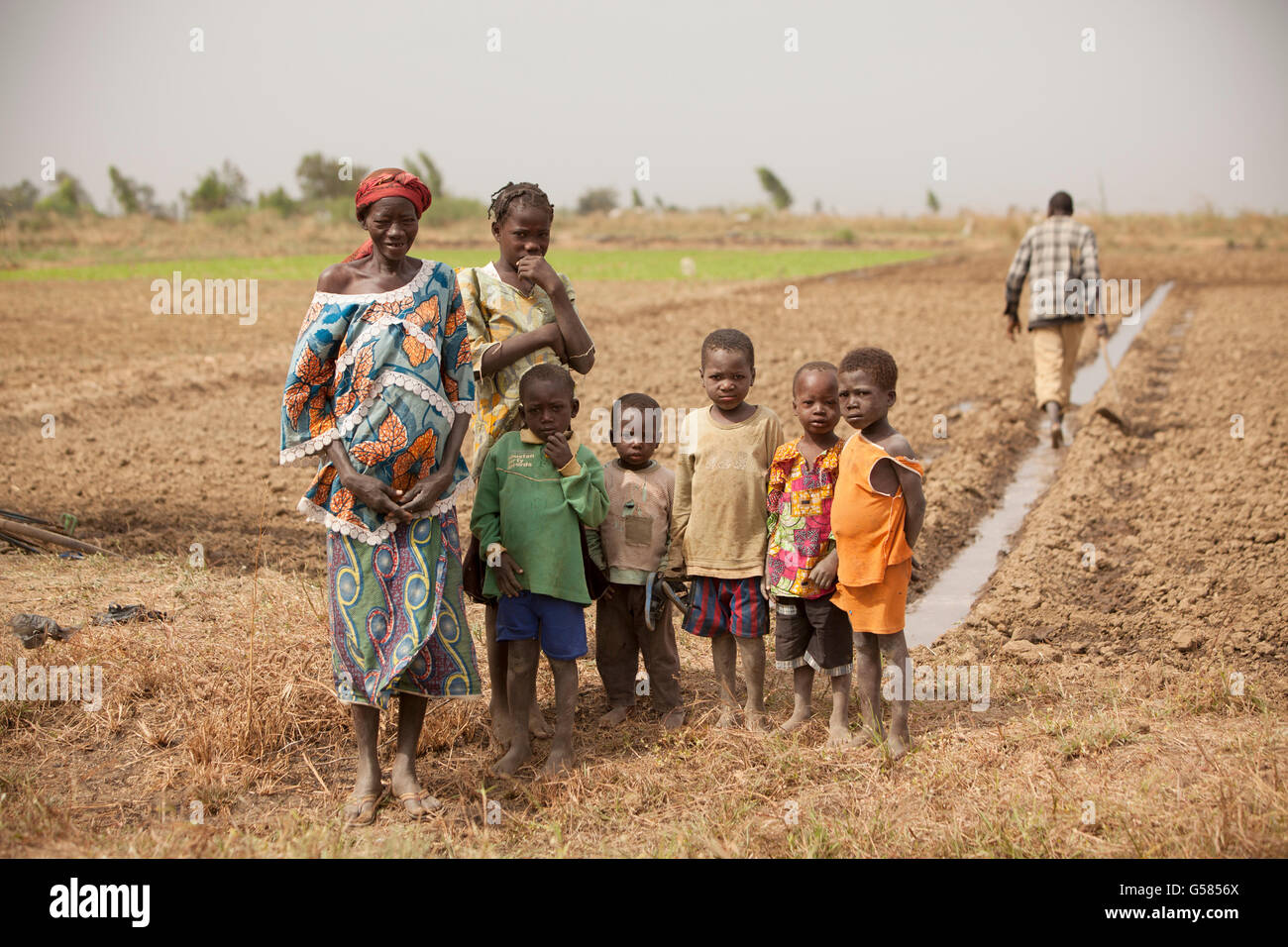 Una famiglia di agricoltori sorge in un campo irrigato in di reparto, Burkina Faso, Africa occidentale. Foto Stock