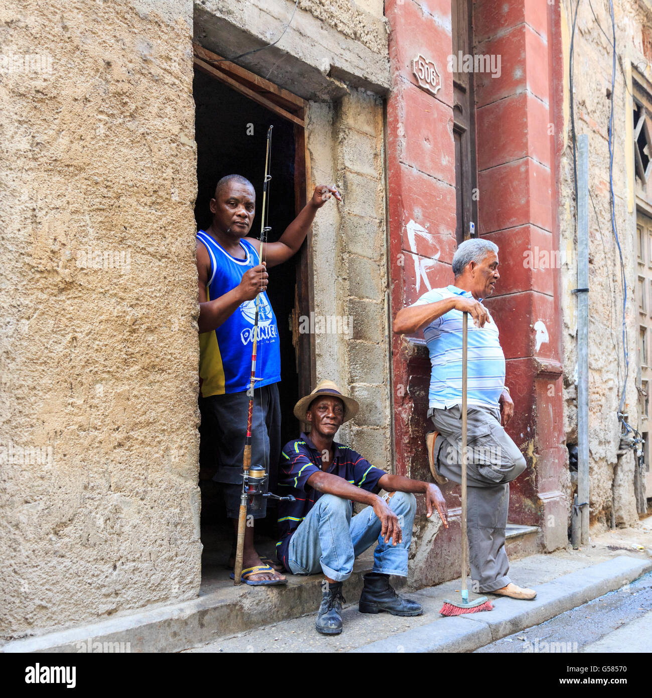 Havana street scene, tre uomini cubani in chat con La Habana Vieja, Cuba Foto Stock