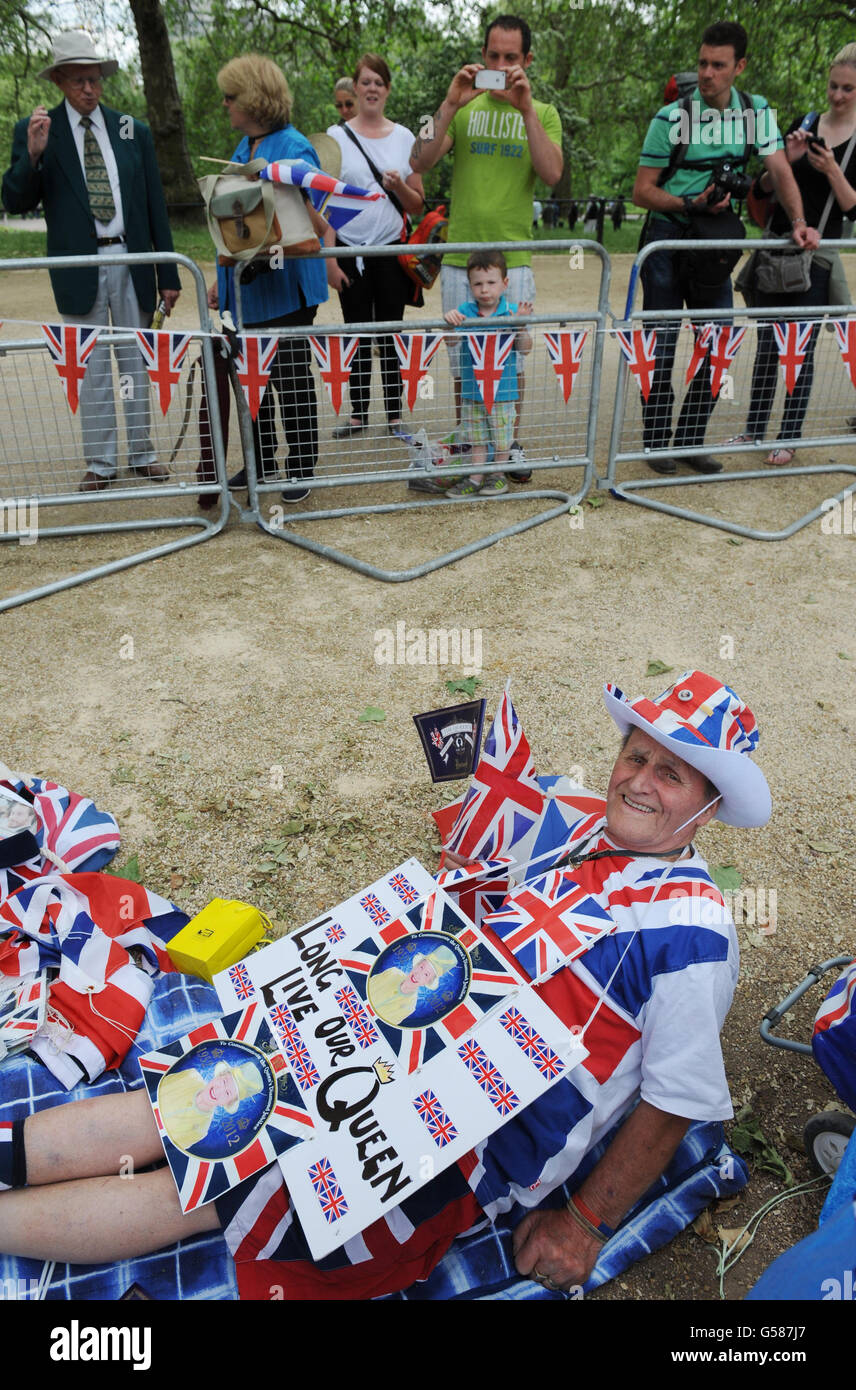 I membri del pubblico si fermano a guardare Terry Hutt, da Cambridge, mentre accampava sul Mall in previsione delle celebrazioni del Giubileo del Diamante del fine settimana. Foto Stock