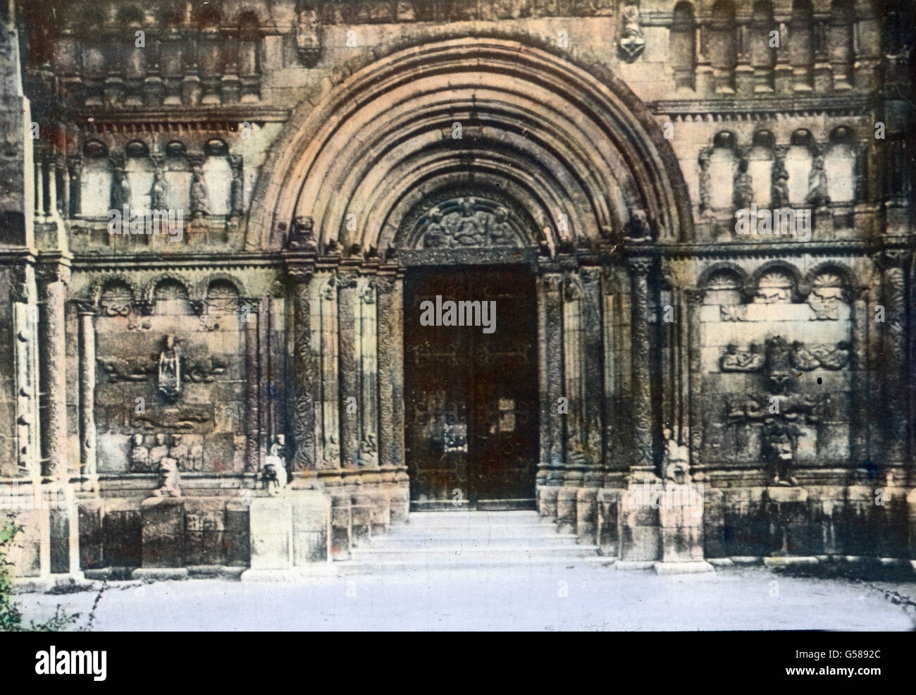 Das Prunkstück dieses Heiligtums der Schottenmönche jedoch ist das Portal der Kirche St. Jakob in Regensburg. Die Anlage wird von zwei weitvortretenden Pfeilern eingerahmt, Säulen vermitteln den Übergang zur Portalwand, die durch Horizontalbänder in Sockelhohes Untergeschoß und zwei Stockwerke niedrige zerlegt wird. Je drei rundbogen, deren äußerste auf Säulen ruhen, gliedern das unterste Stockwerk, je vier Menschen- und Tierköpfe beherbergend und von sitzenden getragenm Figuren das mittlere, je fünf durch Pfeiler und Säulenvorlagen gestützte Rundbogen, das obere Geschoß. Reich ist der plastis Foto Stock