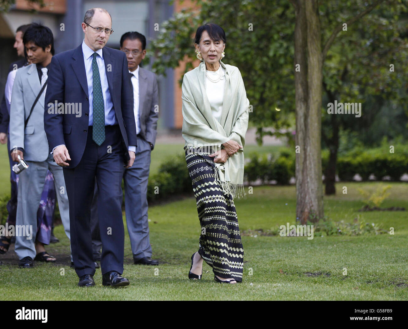 Aung San Suu Kyi, un attivista birmano a favore della democrazia, cammina con Andrew Dilnot, il direttore del St Hugh's College dell'Università di Oxford, in un ricevimento ad Oxford. Foto Stock