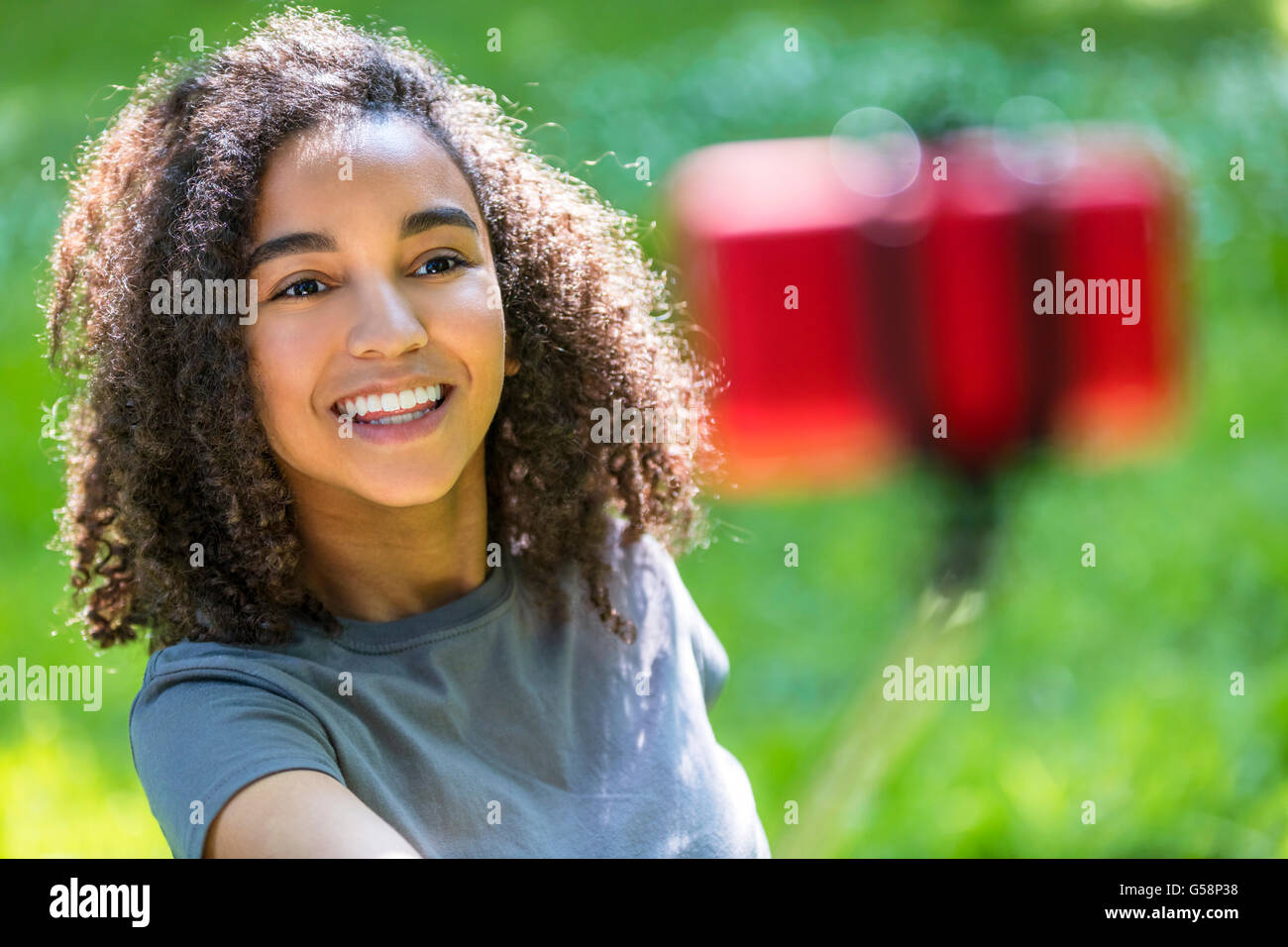 Bella felice razza mista americano africano donna giovane ragazza adolescente femmina sorridente bambino perfetto denti tenendo selfie foto Foto Stock