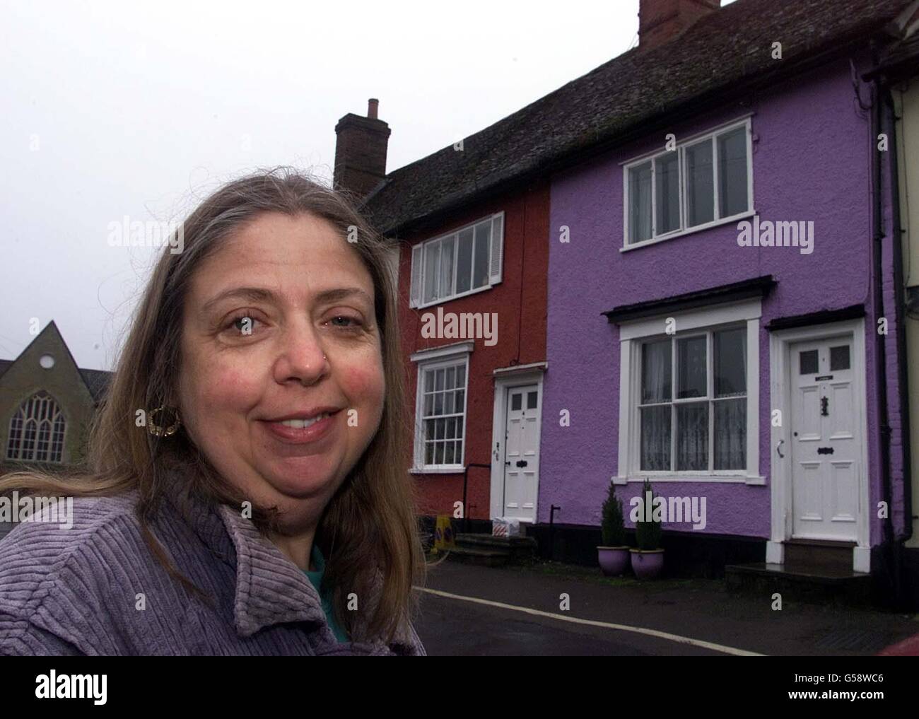 Janice Daines fuori della sua casa lilla-dipinta, nel villaggio di Clare, Suffolk. Janice ha promesso che preferirebbe una pena detentiva piuttosto che ripassare la sua casa dopo che i Consiglieri di Suffolk hanno chiuso una domanda di pianificazione per mantenere il suo lilac domestico di grado II elencato. Foto Stock