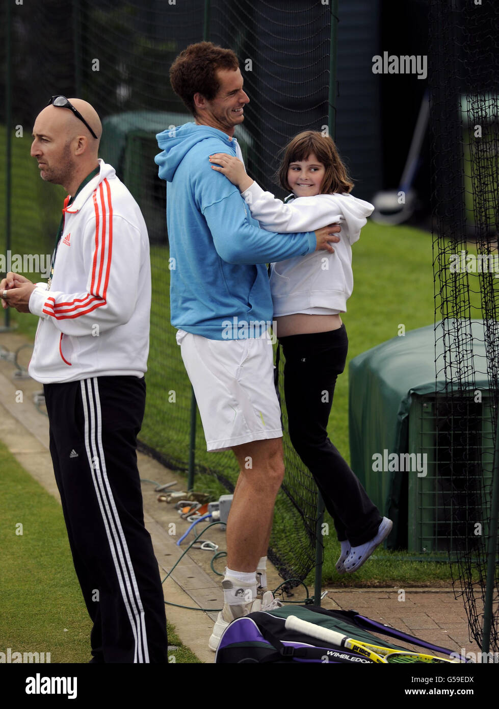 Andy Murray della Gran Bretagna con la nipote di sua mamma Cora Erskine (di 9 anni) durante la pratica il giorno cinque dei campionati di Wimbledon 2012 all'All England Lawn Tennis Club di Wimbledon. Foto Stock