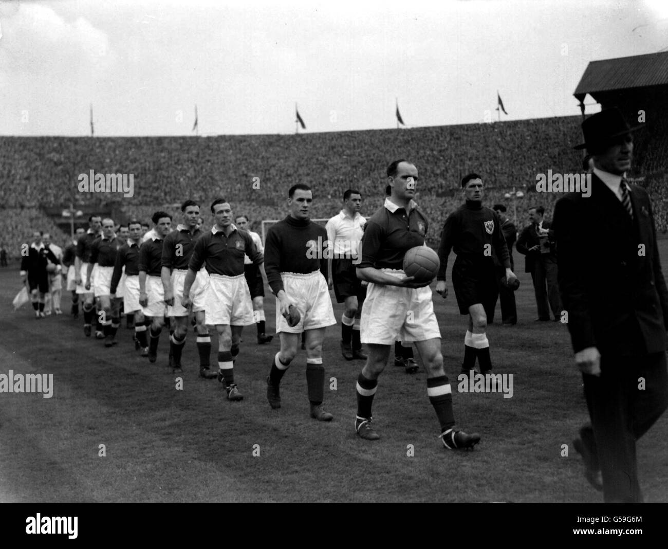 1948: Manchester United, nelle magliette Royal Blue, e Blackpool, nelle camicie bianche, escono sul campo all'inizio della finale della fa Cup a Wembley, Londra. Foto Stock