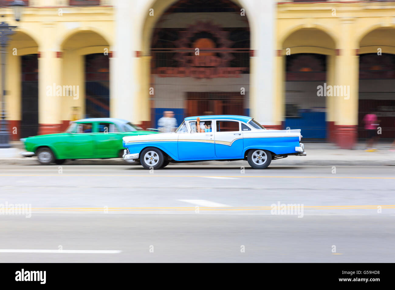Il panning shot of American auto d'epoca che viaggiano in Paseo de Marti, Old Havana, Cuba Foto Stock