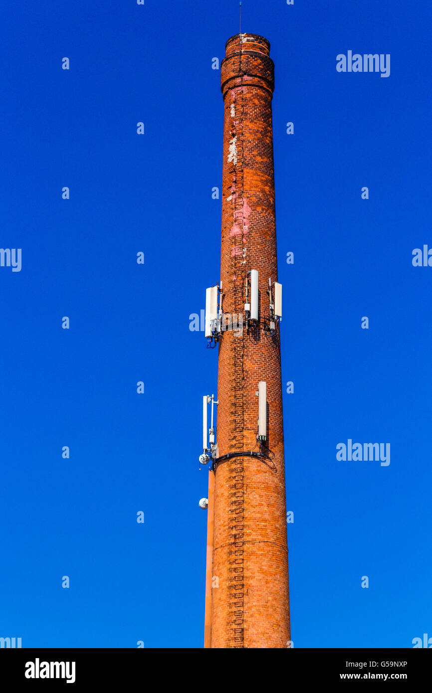 Vecchia ciminiera in mattoni come ripetitori cellulari Foto Stock