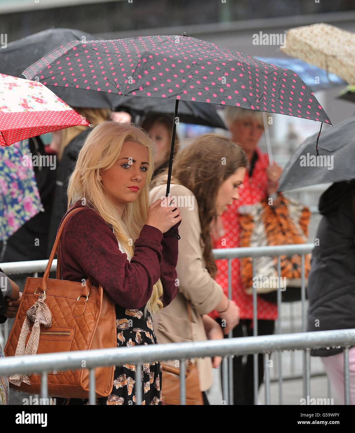 I fan che aspettano sotto la pioggia prima dell'X Factor Bootcamp all'Echo Arena di Liverpool. Foto Stock