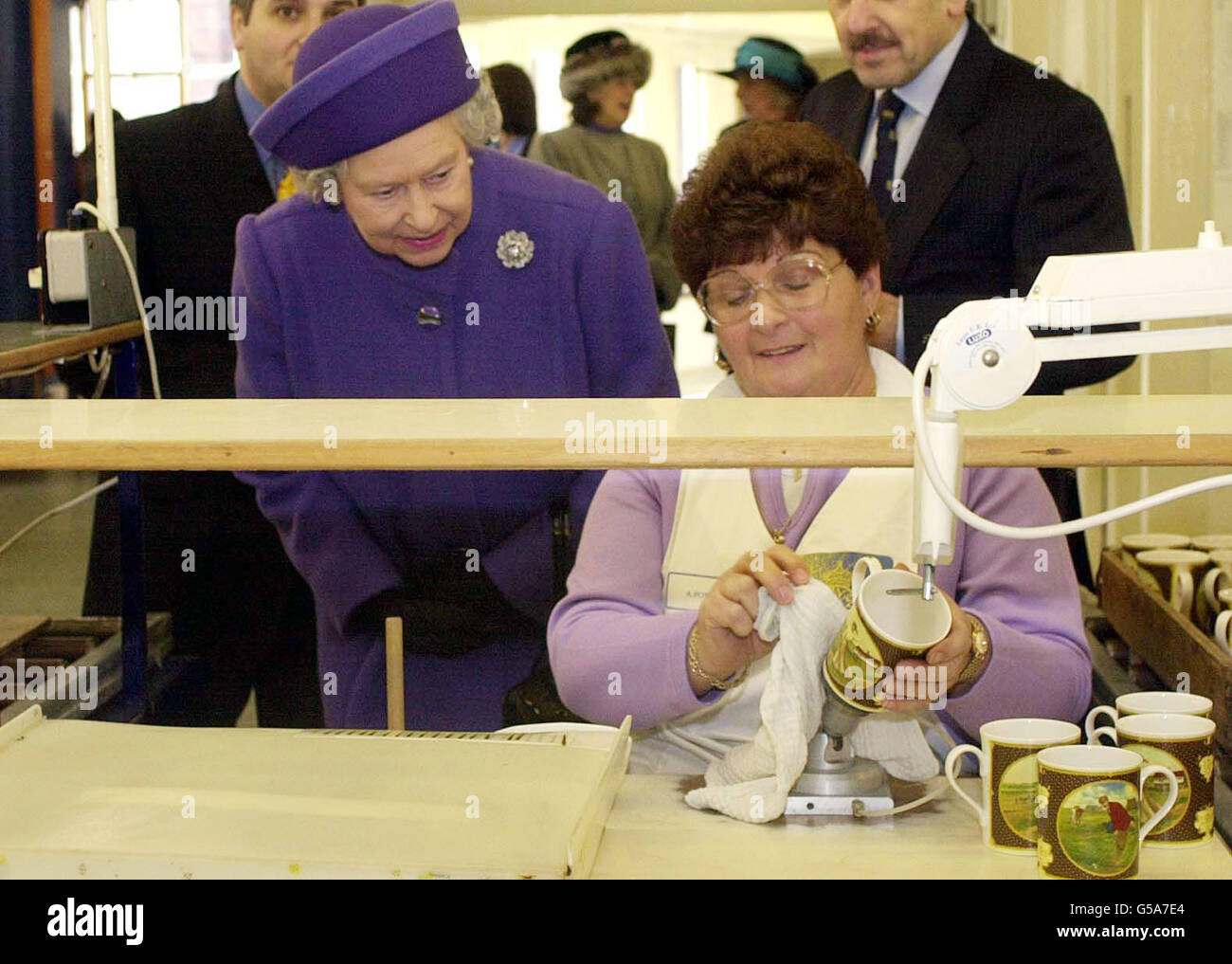 La regina Elisabetta II (a sinistra) guarda Anne Fowler decorare la porcellana durante una visita alla porcellana di Worcester reale, in Worcester. Foto Stock