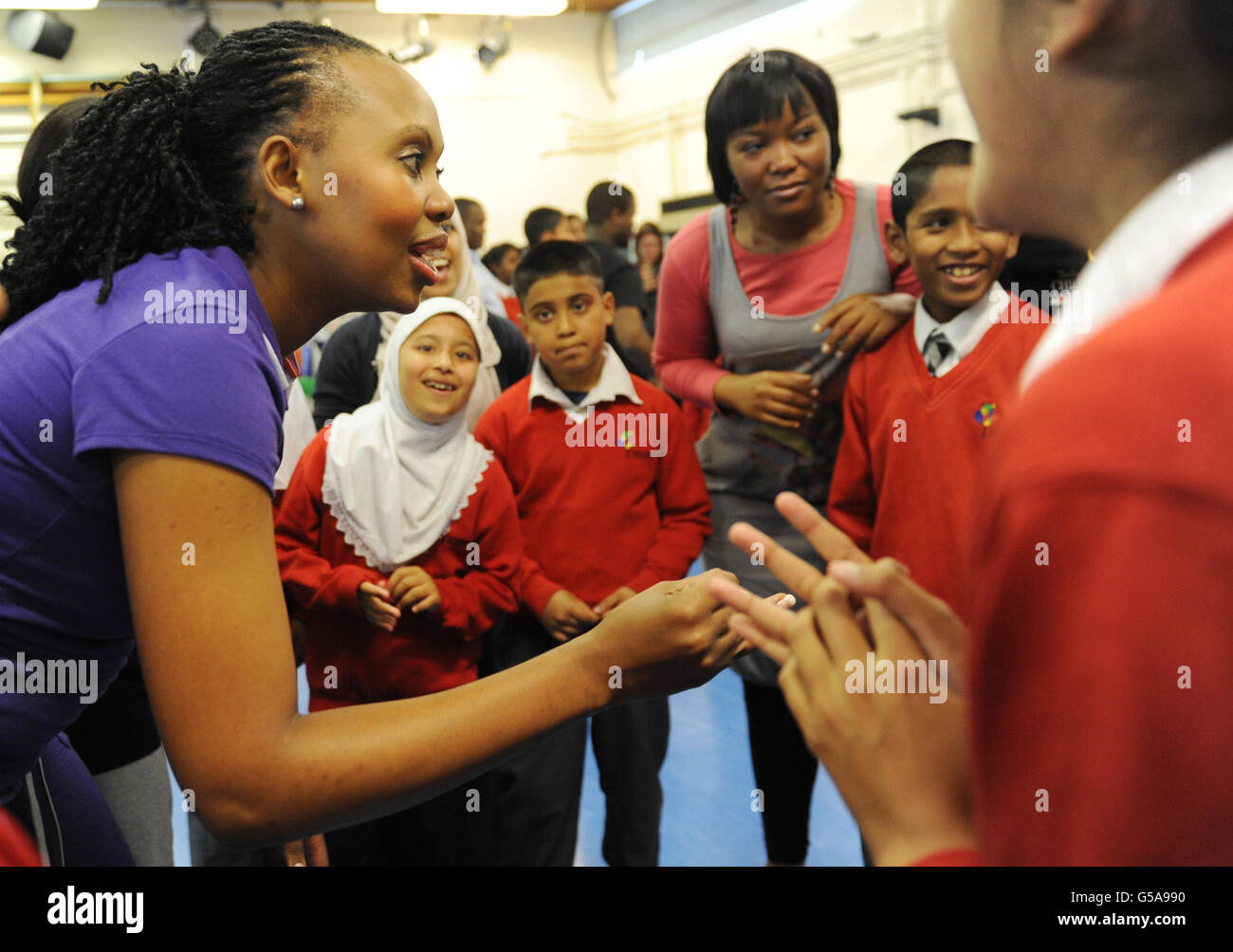 I membri del Cape Town Opera a sostegno del Nelson Mandela Children's Fund UK insegnano agli studenti a cantare oggi alla Thomas Buxton Primary School nella zona est di Londra. Foto Stock