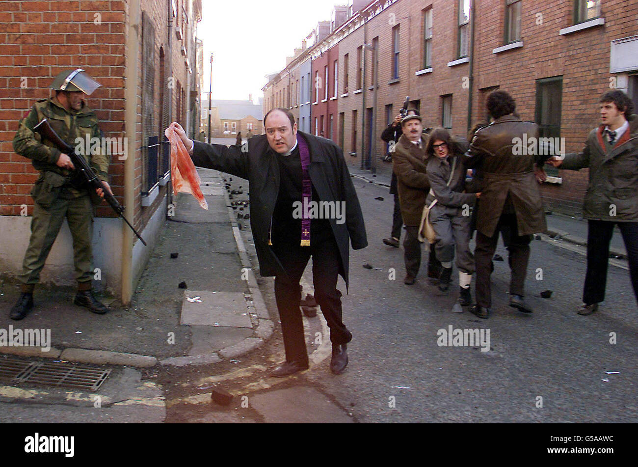 L'attore nato di Portadown Brian Devlin raffigurante il padre Edward Daly con un fazzoletto imbibito di sangue sulla domenica di Bloody. Le strade intorno al Boggside a Londonderry sono state trasformate per la realizzazione di film televisivi sulle 1972 sparatorie di Paratroopers. * questa famosa scena fu catturata a quel tempo da fotografi e mostrò che l'adolescente ferito a morte Jackie Duddy veniva trasportato dall'area. Il vescovo Daly, come è ormai noto, ha dato prova alla Bloody Sunday Inquiry solo poche settimane fa e a pochi metri dalla scena in cui il film è stato girato. Foto Stock