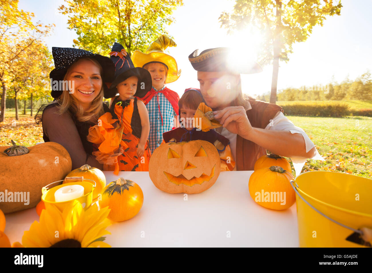 La famiglia in costumi di Halloween craft Jack-O-Lantern Foto Stock
