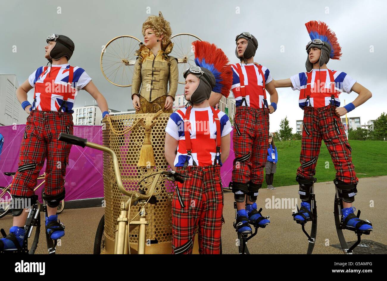 La vista che saluta gli atleti in arrivo al loro Villaggio Olimpico nella parte est di Londra, dove i membri del Teatro Nazionale della Gioventù della Gran Bretagna li accolgono con le routine di canto e danza, con una settimana fino all'inizio dei giochi di Londra 2012. Foto Stock