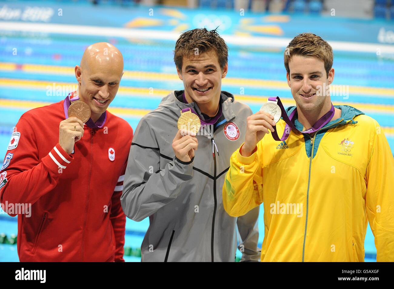 Adrian Nathan (centro) degli Stati Uniti celebra la sua medaglia d'oro accanto al medaglia d'argento James Magnussen (destra) dell'Australia e Brent Hayden del Canada con Bronze, seguendo la 100m Freestyle Final degli uomini Foto Stock