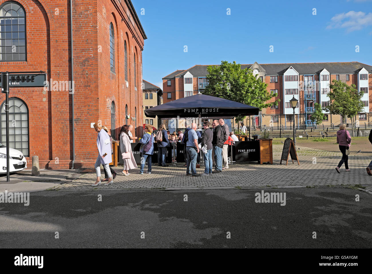Le persone aventi un drink al di fuori della pompa House Pub e Grill su un giugno estati sera a Swansea Marina, Wales UK KATHY DEWITT Foto Stock