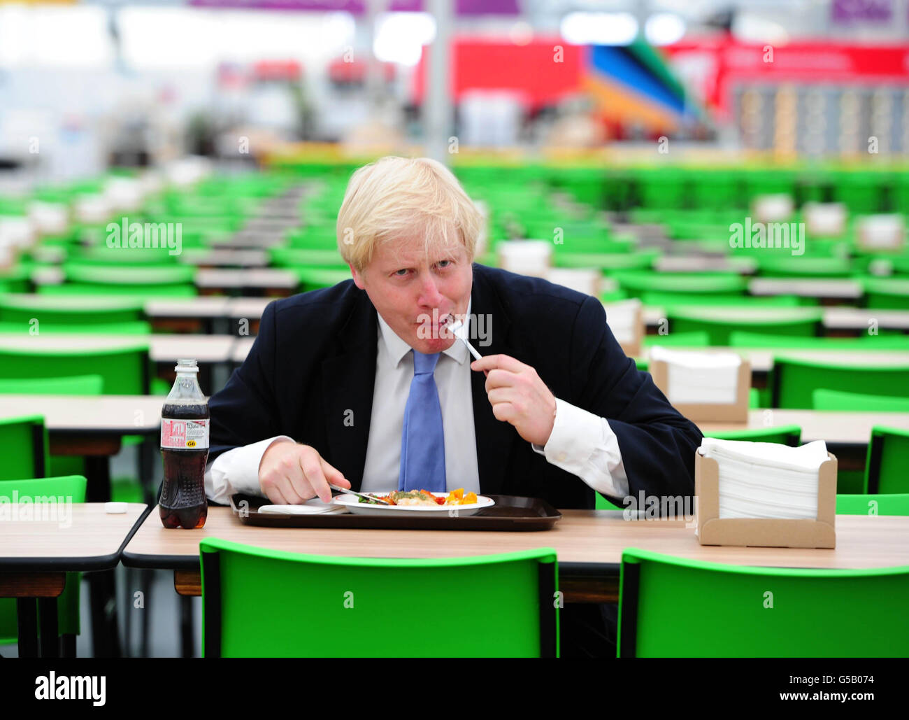 Il Sindaco di Londra Boris Johnson ha un assaggio di alcuni dei piatti offerti alla Food Hall nel Villaggio Olimpico durante un tour mediatico del Villaggio Olimpico di Londra. Foto Stock