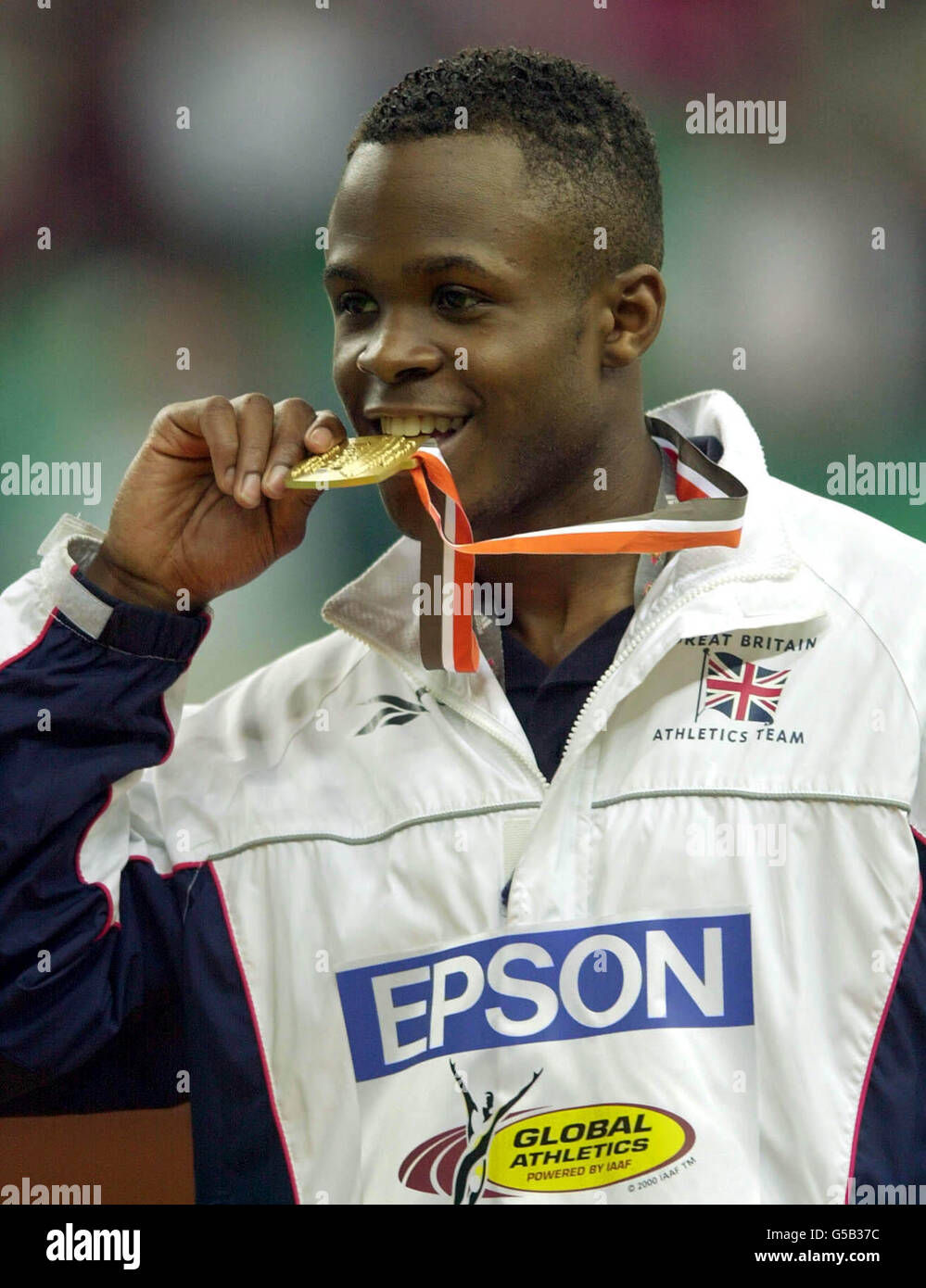 Daniel Caines, il Gran Bretagna, assaggia la sua nuova medaglia d'oro dopo aver vinto la finale di 60 metri durante l'ottavo campionato mondiale indoor IAAF in atletica, all'Atlantic Pavillion di Lisbona, Portogallo. Foto Stock